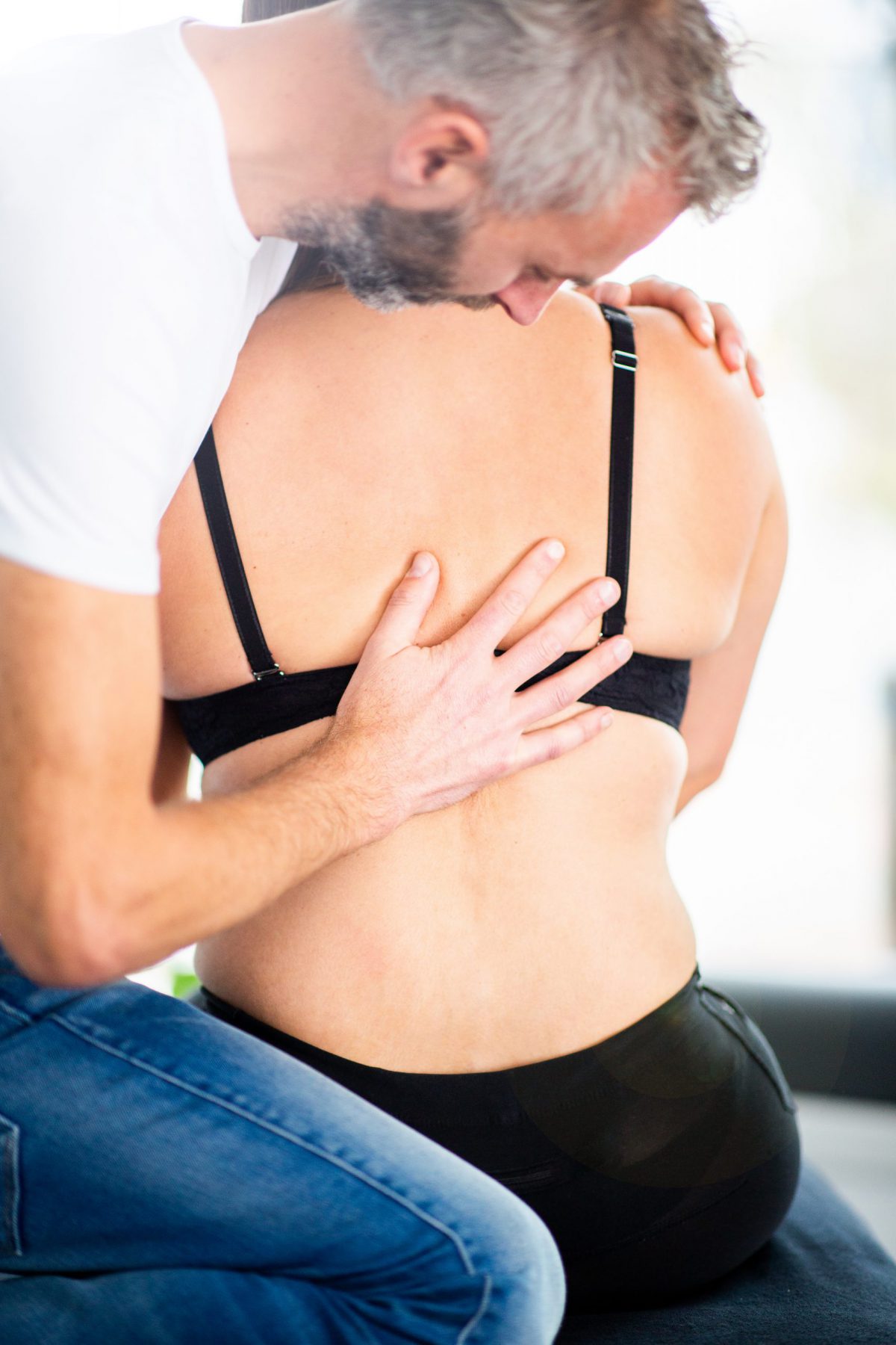 Een osteopaat in Hoofddorp drukt tegen de rug van een vrouw
